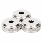 Three silver colored metal knobs with textured edges and central holes